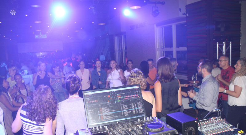 Adult guests dancing in front of a professional DJ setup
